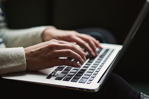 Individual typing on Macbook.