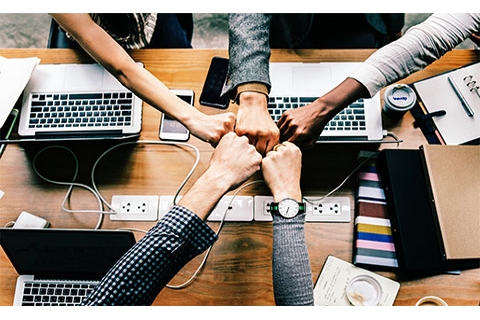 Group putting their hands together as if they were joining together.